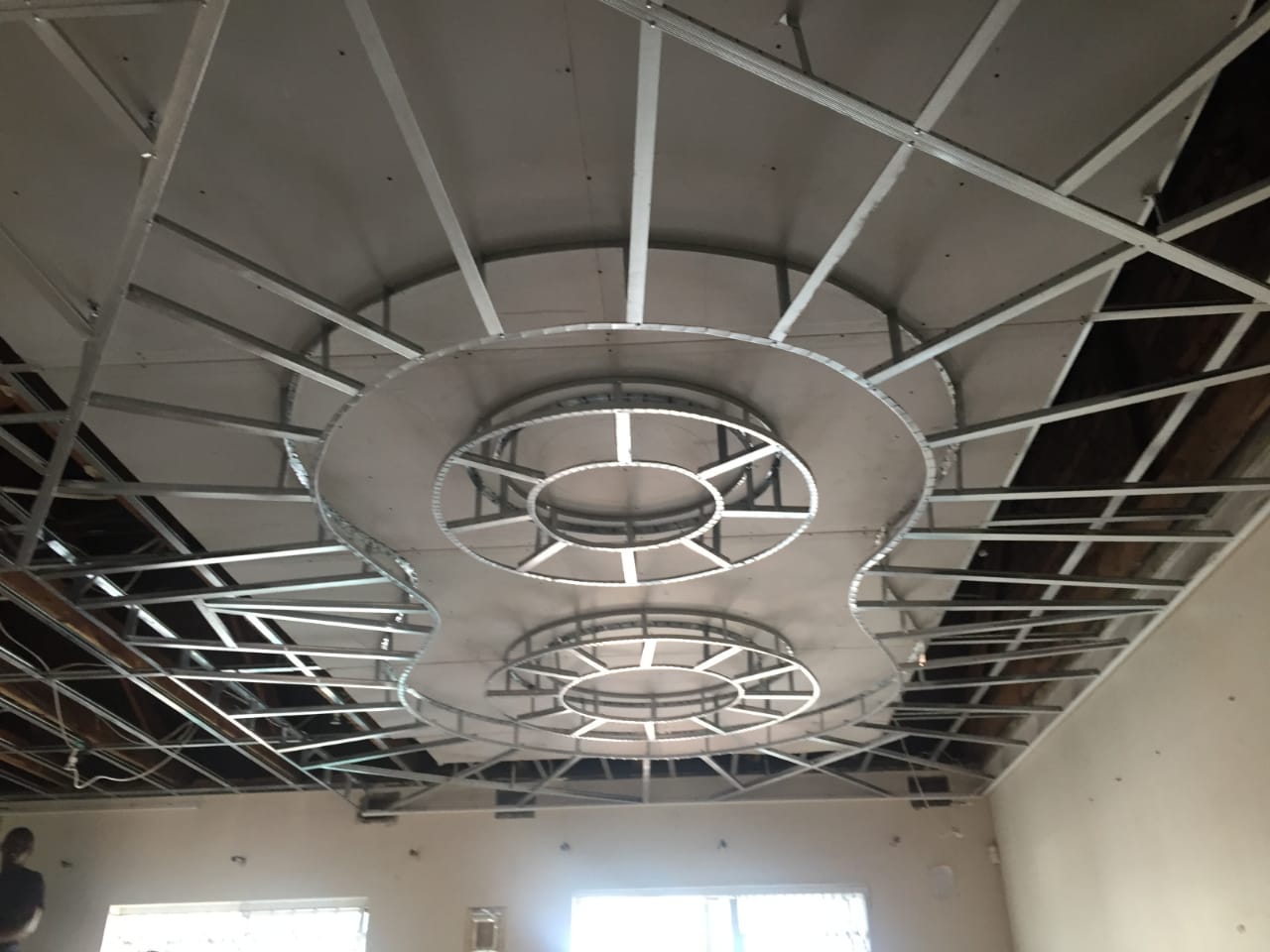 Decorative ceiling frame under construction showing galvanised Main T, Cross T, and wall angle profiles